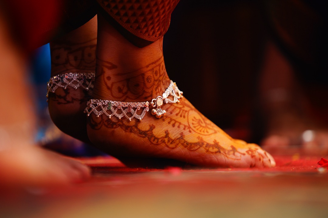 mehandi on her feet with a silver anklet bride on her kerala wedding photography session